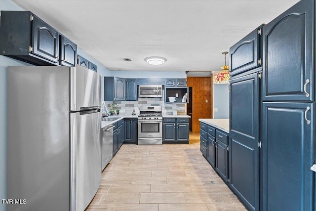 kitchen with stainless steel appliances, a sink, light countertops, backsplash, and open shelves