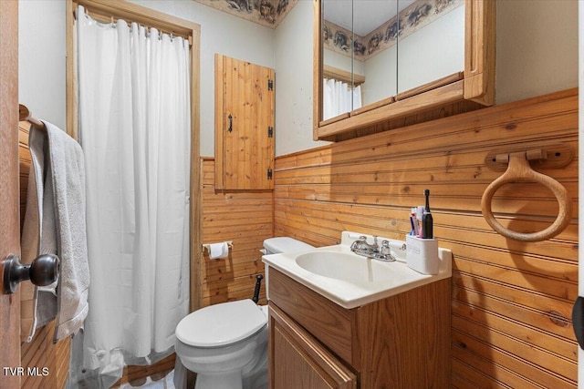 full bathroom featuring toilet, wainscoting, wooden walls, vanity, and a shower with curtain