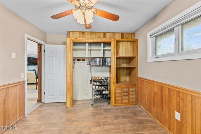 unfurnished bedroom featuring a closet, a wainscoted wall, and wood walls