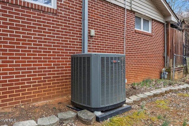 details featuring central air condition unit and brick siding