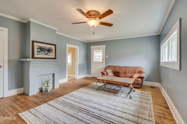 living area with a healthy amount of sunlight, baseboards, and wood finished floors