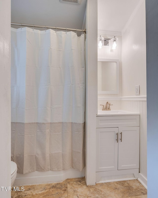 full bathroom featuring visible vents, toilet, a wainscoted wall, shower / tub combo with curtain, and vanity