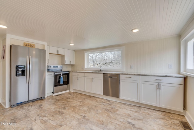 kitchen featuring light stone counters, visible vents, stainless steel appliances, and a wealth of natural light