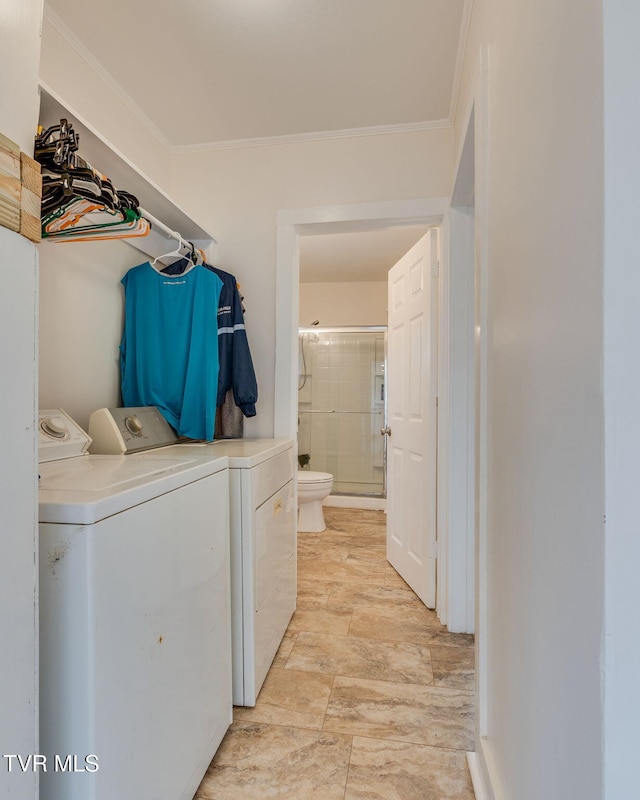 clothes washing area with laundry area, washing machine and clothes dryer, and crown molding