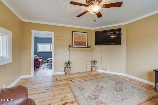 living room featuring crown molding, ceiling fan, wood finished floors, and baseboards