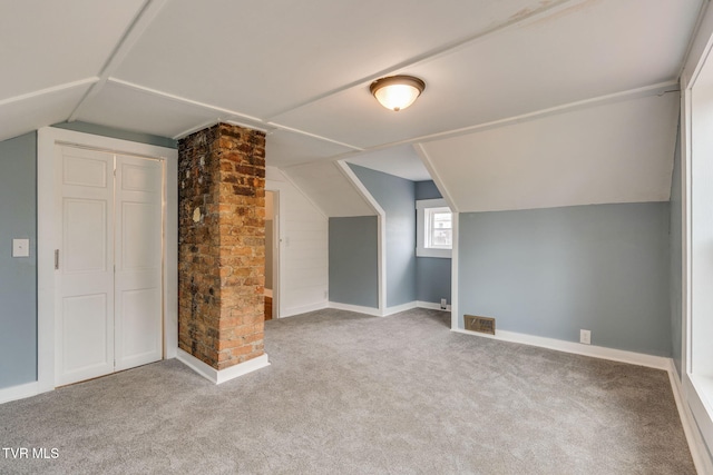 additional living space featuring carpet flooring, vaulted ceiling, visible vents, and baseboards