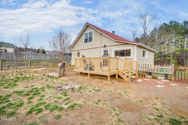 rear view of property featuring fence and a deck