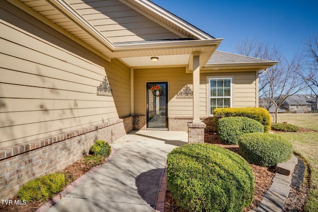 property entrance with brick siding and roof with shingles