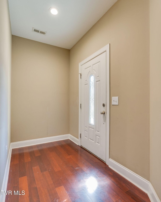 entryway with baseboards, visible vents, and wood finished floors