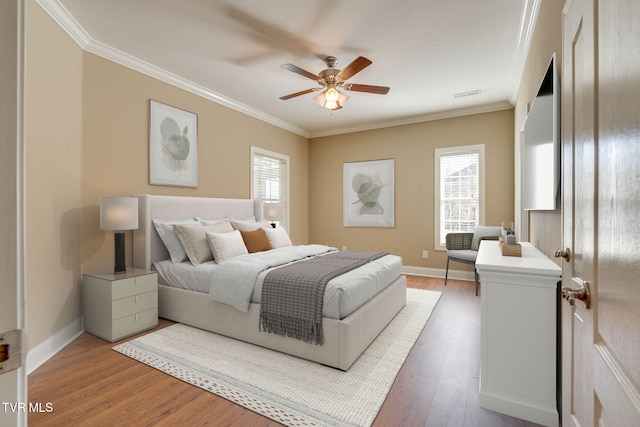 bedroom featuring ornamental molding, baseboards, and light wood finished floors