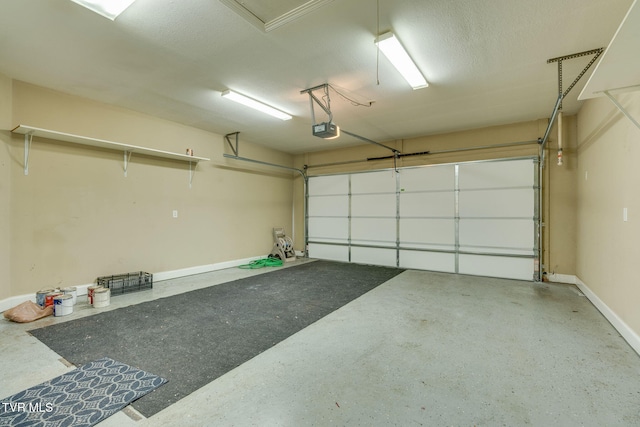 garage featuring a garage door opener and baseboards