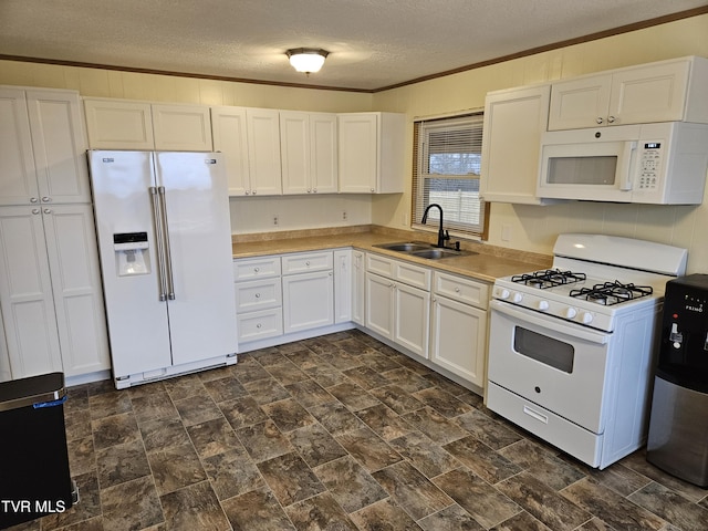 kitchen with light countertops, ornamental molding, white cabinets, a sink, and white appliances