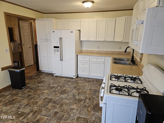 kitchen featuring white appliances, ornamental molding, white cabinets, and a sink