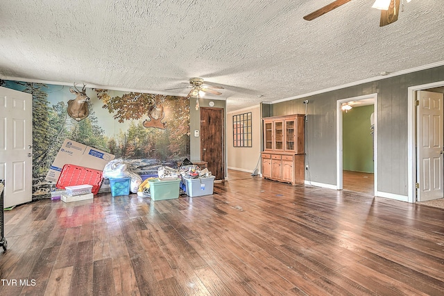 living room with a textured ceiling, wood-type flooring, a ceiling fan, and crown molding