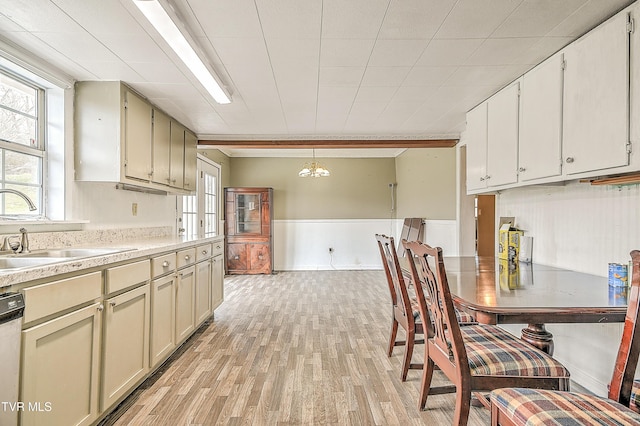 kitchen featuring light wood-style floors, a wealth of natural light, light countertops, and a sink