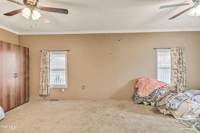 carpeted bedroom with ceiling fan, visible vents, and crown molding