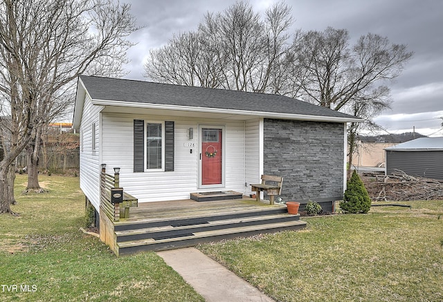 view of front facade featuring roof with shingles and a front lawn