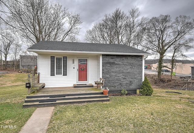 bungalow-style house with a shingled roof and a front yard