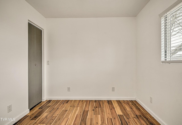 empty room with baseboards and wood finished floors