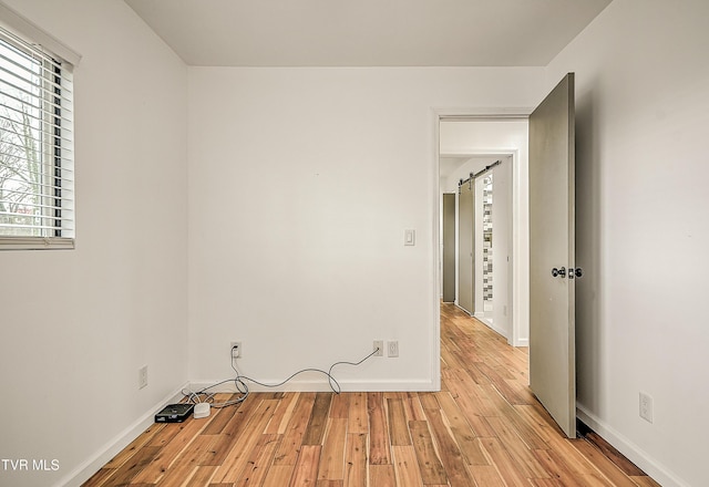 empty room with baseboards and light wood finished floors