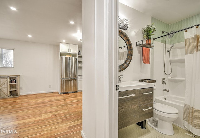 bathroom with shower / tub combo, toilet, wood finished floors, vanity, and recessed lighting