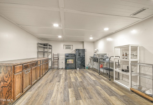 bar featuring freestanding refrigerator, light wood finished floors, oven, and visible vents