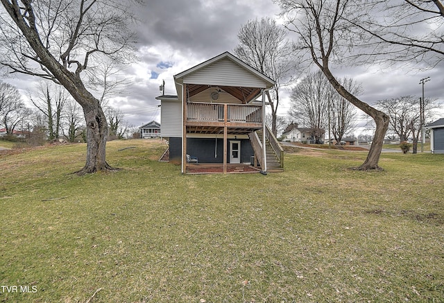 rear view of house featuring a wooden deck, stairway, and a yard