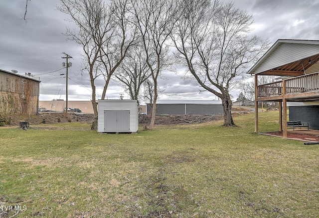 view of yard featuring an outbuilding, a deck, and a storage unit