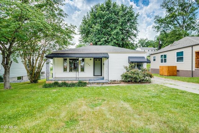 view of front of property with a porch, driveway, a front lawn, and roof with shingles