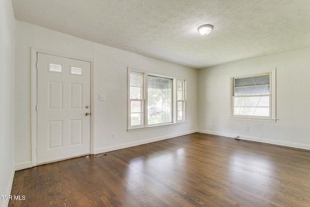 foyer with baseboards, dark wood-style flooring, and a textured ceiling