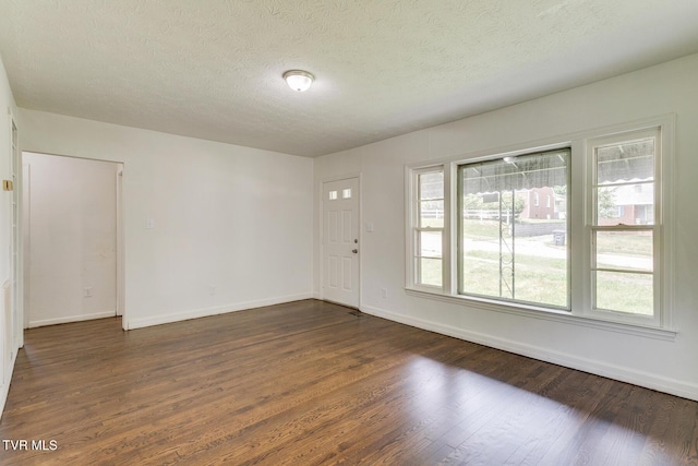 interior space featuring baseboards, a textured ceiling, and dark wood-style flooring