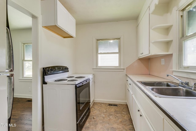 kitchen with a sink, visible vents, range with electric stovetop, and a wealth of natural light