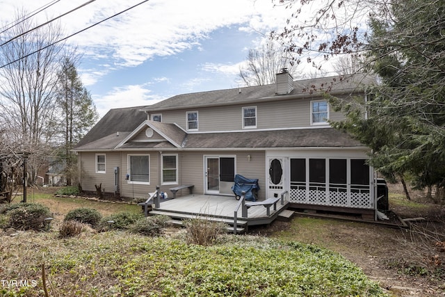 back of house featuring a deck, a chimney, and a sunroom