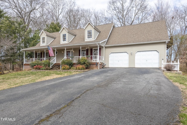 cape cod home with an attached garage, covered porch, aphalt driveway, and roof with shingles