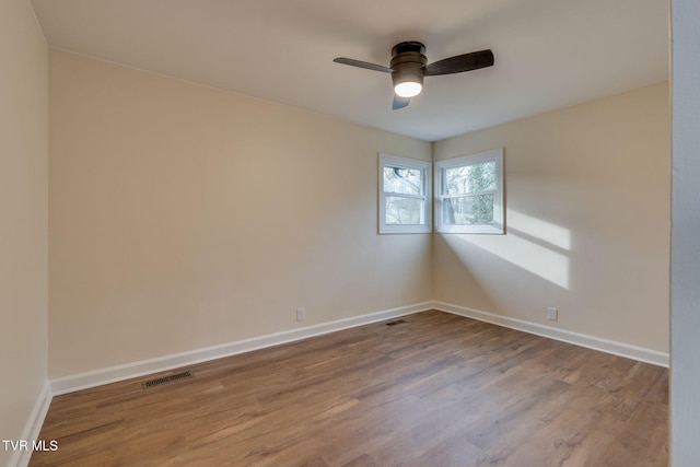 unfurnished room with visible vents, baseboards, ceiling fan, and wood finished floors