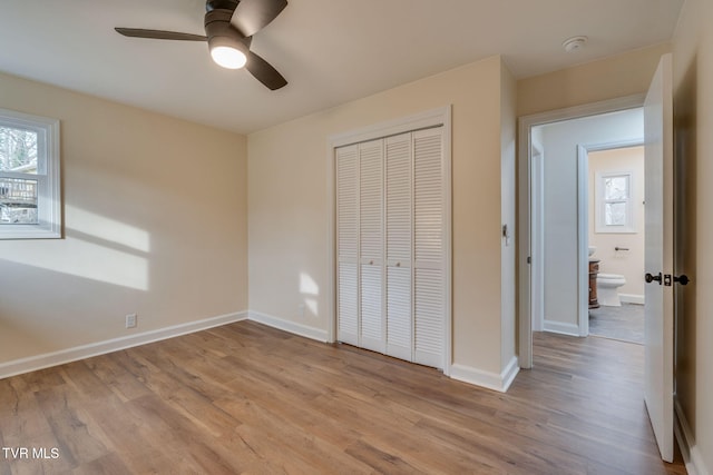 unfurnished bedroom featuring light wood-type flooring, baseboards, and a closet