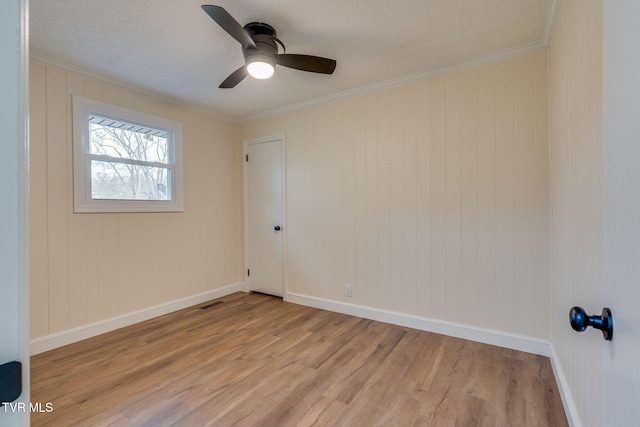 empty room with visible vents, crown molding, ceiling fan, light wood-style flooring, and a textured ceiling