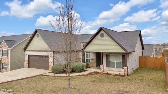 craftsman inspired home featuring a garage, fence, driveway, roof with shingles, and a front lawn