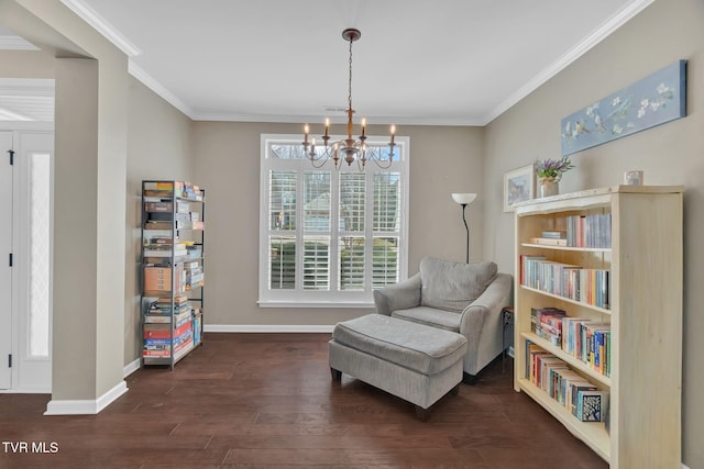 living area featuring a notable chandelier, baseboards, ornamental molding, and wood finished floors