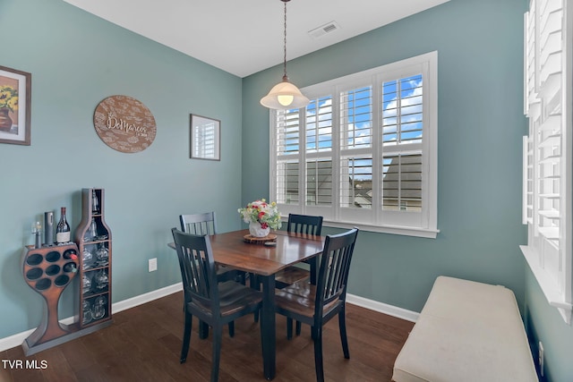 dining room with dark wood-style floors, visible vents, and baseboards