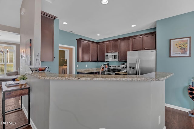 kitchen featuring appliances with stainless steel finishes, independent washer and dryer, dark brown cabinets, and dark wood-style floors