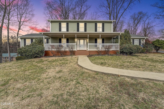 view of front of property with a porch and a yard