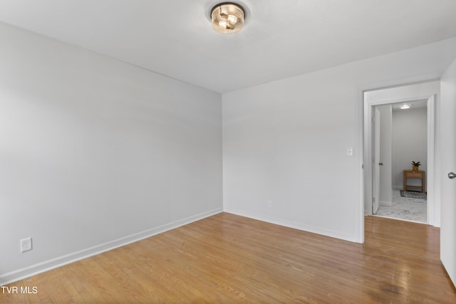 spare room featuring wood finished floors and baseboards