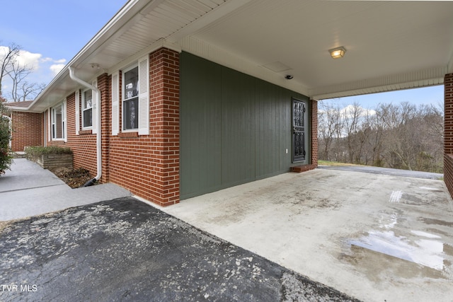 view of home's exterior featuring concrete driveway and brick siding