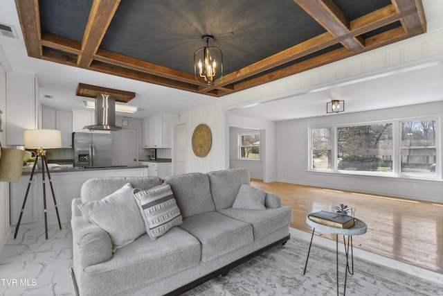 living area featuring a chandelier, marble finish floor, visible vents, and baseboards