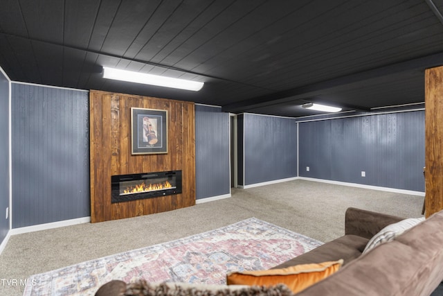 living area featuring baseboards, carpet flooring, and a glass covered fireplace