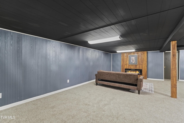 interior space with a lit fireplace, carpet, and wood ceiling