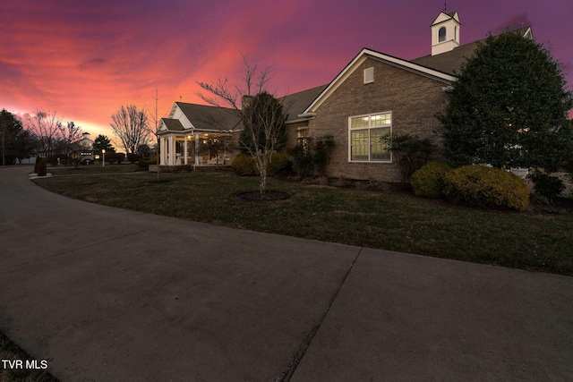 view of front of home with brick siding and a front yard