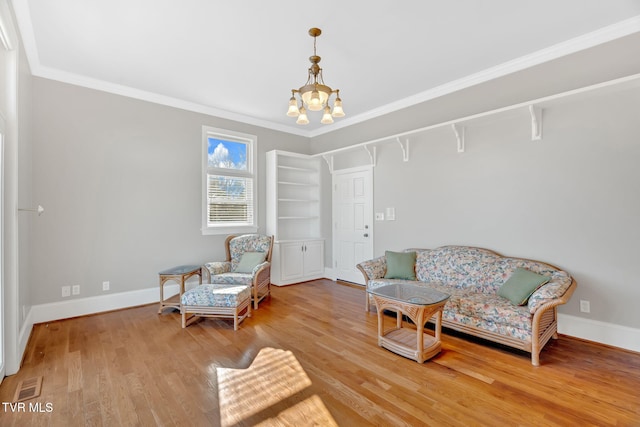 sitting room featuring visible vents, a notable chandelier, baseboards, and wood finished floors