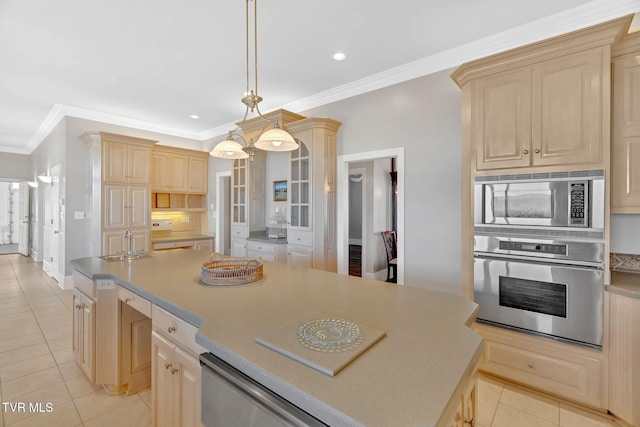 kitchen with light tile patterned floors, stainless steel appliances, a sink, a kitchen island, and crown molding